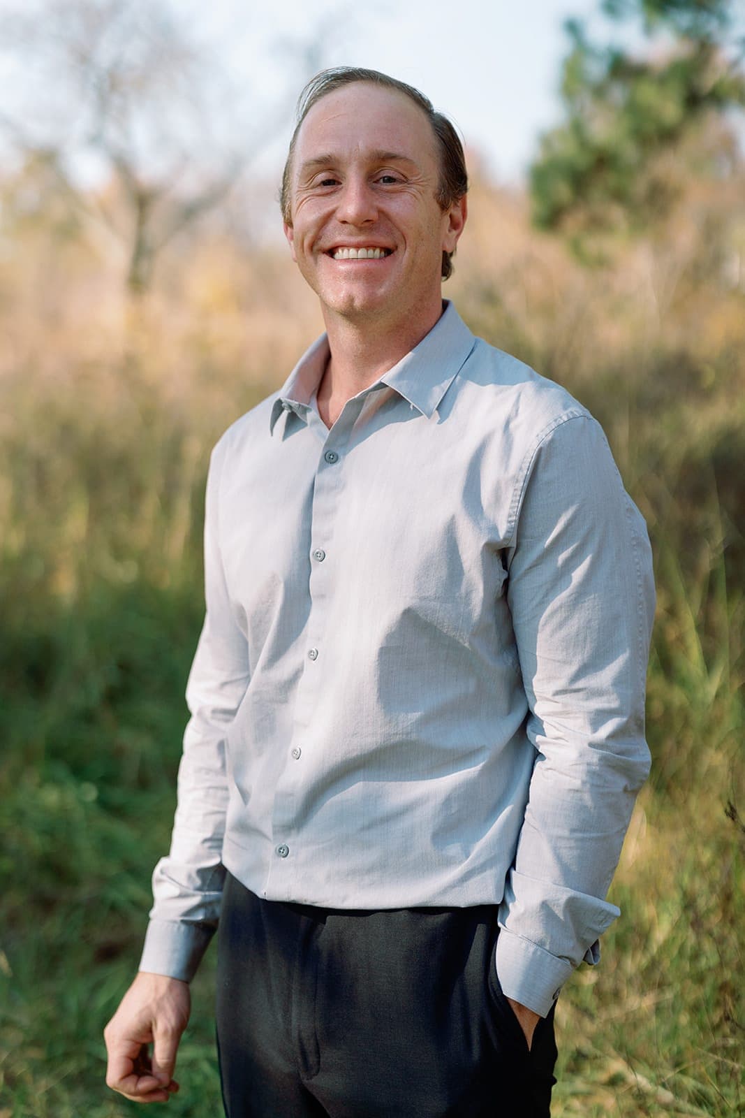 Dr. Daniel Tagge outdoors in an open field, smiling